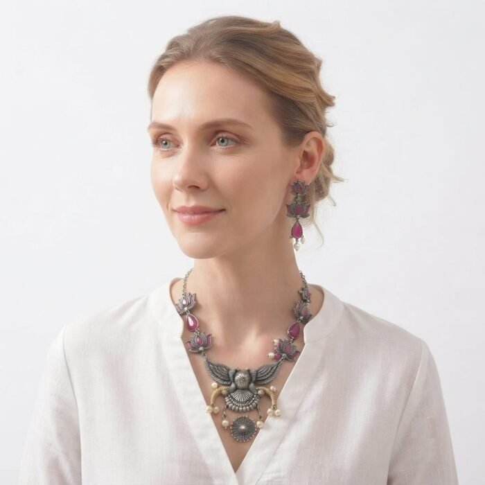 Beautiful oxidised silver necklace set featuring pink teardrop stones, lotus-inspired motifs, an intricate peacock pendant, and matching earrings.